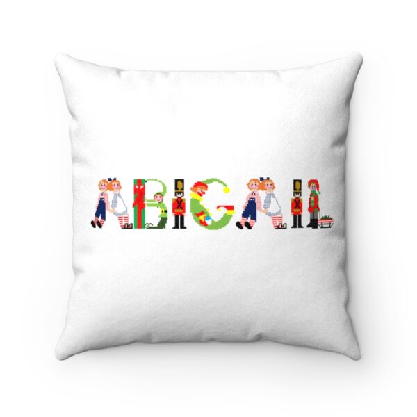 White faux suede cushion with text ‘Abigail’ in colourful Christmas themed lettering