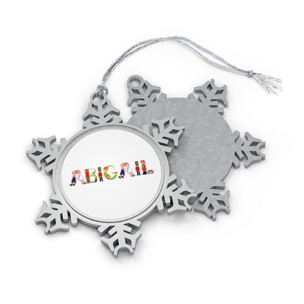 Silver-toned snowflake ornament with white insert with text ‘Abigail’ in colourful Christmas themed lettering, with silver hanging loop