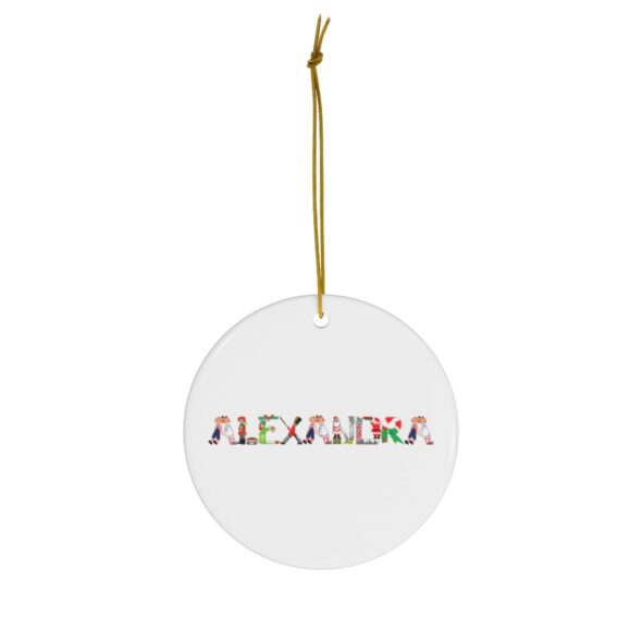 White ceramic ornament with text ‘Alexandra’ in colourful Christmas themed lettering, with gold hanging loop