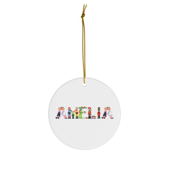 White ceramic ornament with text ‘Amelia’ in colourful Christmas themed lettering, with gold hanging loop