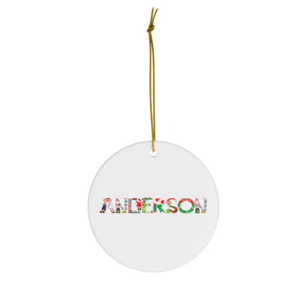 White ceramic ornament with text ‘Anderson’ in colourful Christmas themed lettering, with gold hanging loop