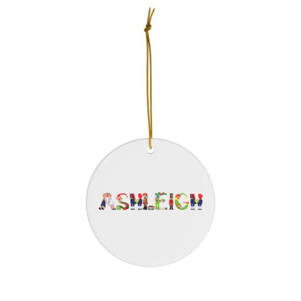 White ceramic ornament with text ‘Ashleigh’ in colourful Christmas themed lettering, with gold hanging loop