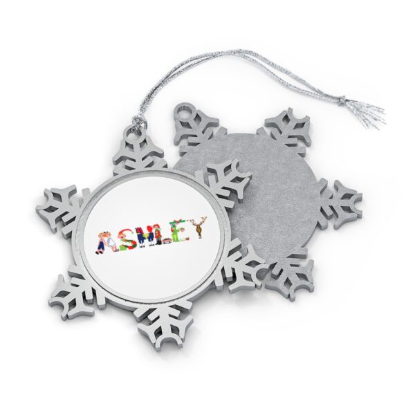 Silver-toned snowflake ornament with white insert with text ‘Ashley’ in colourful Christmas themed lettering, with silver hanging loop