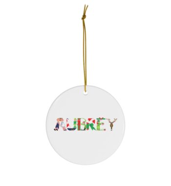 White ceramic ornament with text ‘Aubrey’ in colourful Christmas themed lettering, with gold hanging loop