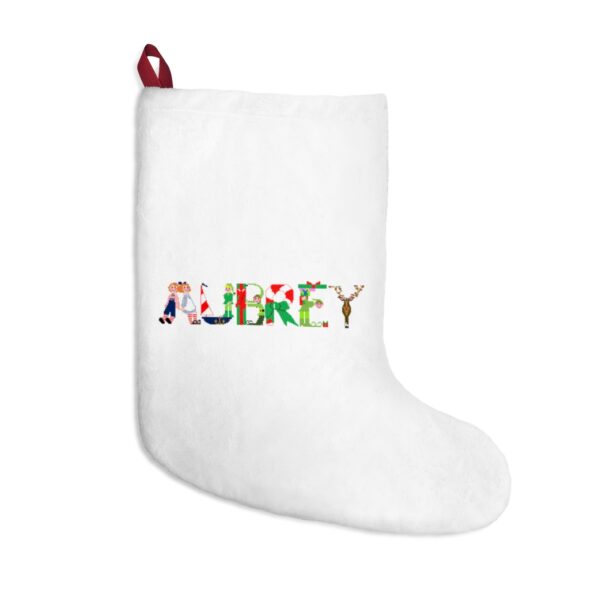 White stocking with text ‘Aubrey’ in colourful Christmas themed lettering, with red hanging loop