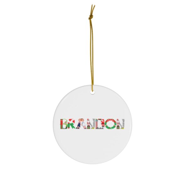 White ceramic ornament with text ‘Brandon’ in colourful Christmas themed lettering, with gold hanging loop