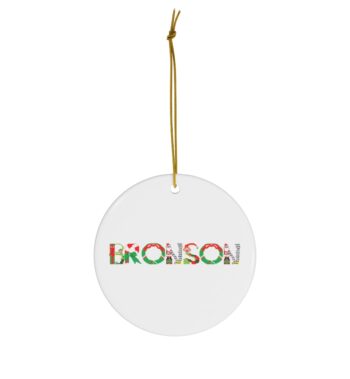 White ceramic ornament with text ‘Bronson’ in colourful Christmas themed lettering, with gold hanging loop