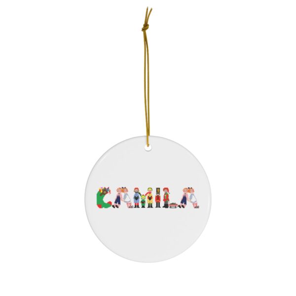 White ceramic ornament with text ‘Camila’ in colourful Christmas themed lettering, with gold hanging loop