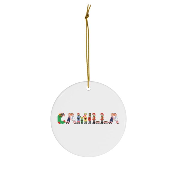 White ceramic ornament with text ‘Camilla’ in colourful Christmas themed lettering, with gold hanging loop