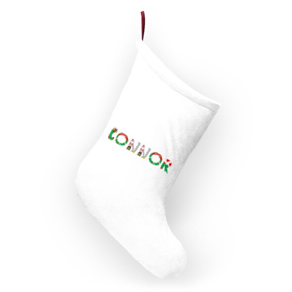 White stocking with text ‘Connor’ in colourful Christmas themed lettering, with red hanging loop