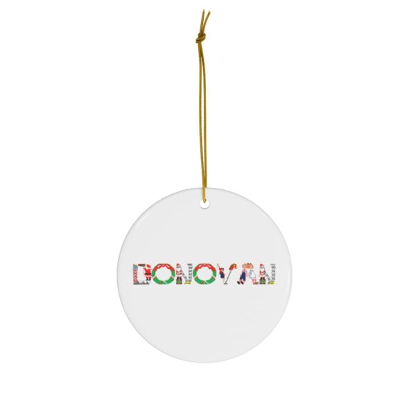 White ceramic ornament with text ‘ Donovan’ in colourful Christmas themed lettering, with gold hanging loop