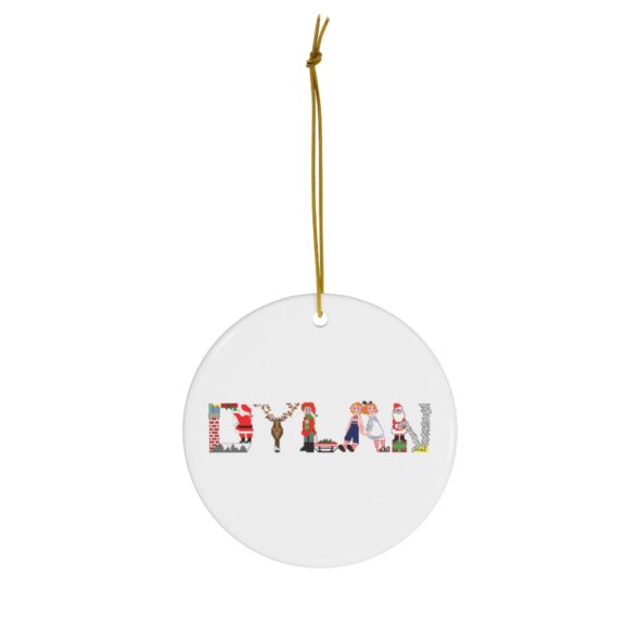 White ceramic ornament with text ‘Dylan’ in colourful Christmas themed lettering, with gold hanging loop