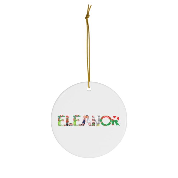 White ceramic ornament with text ‘Eleanor’ in colourful Christmas themed lettering, with gold hanging loop