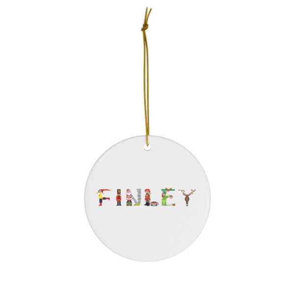 White ceramic ornament with text ‘Finley’ in colourful Christmas themed lettering, with gold hanging loop