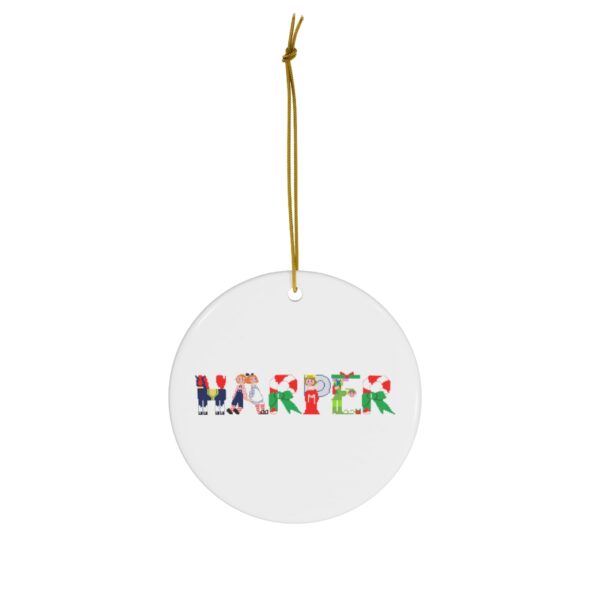 White ceramic ornament with text ‘Harper’ in colourful Christmas themed lettering, with gold hanging loop
