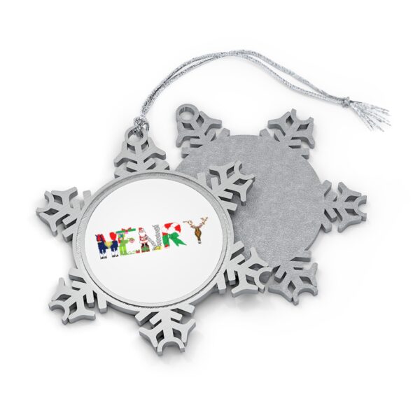 Silver-toned snowflake ornament with white insert with text ‘Henry’ in colourful Christmas themed lettering, with silver hanging loop
