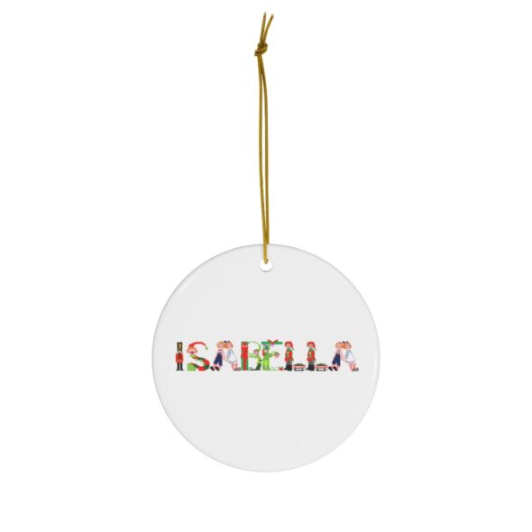 White ceramic ornament with text ‘Isabella’ in colourful Christmas themed lettering, with gold hanging loop