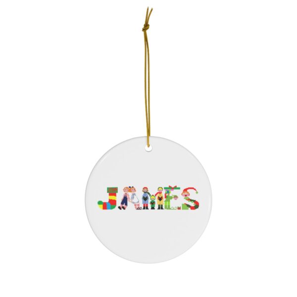 White ceramic ornament with text ‘James’ in colourful Christmas themed lettering, with gold hanging loop