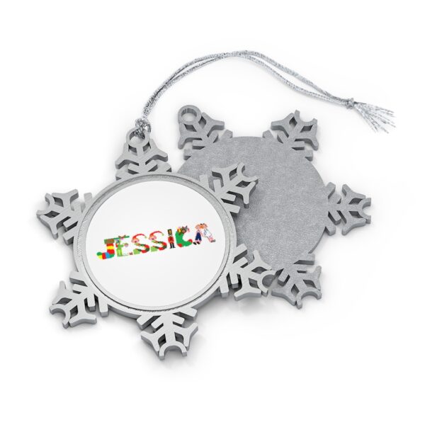 Silver-toned snowflake ornament with white insert with text ‘Jessica’ in colourful Christmas themed lettering, with silver hanging loop