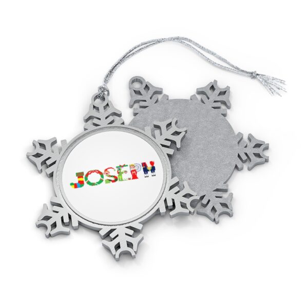 Silver-toned snowflake ornament with white insert with text ‘Joseph’ in colourful Christmas themed lettering, with silver hanging loop