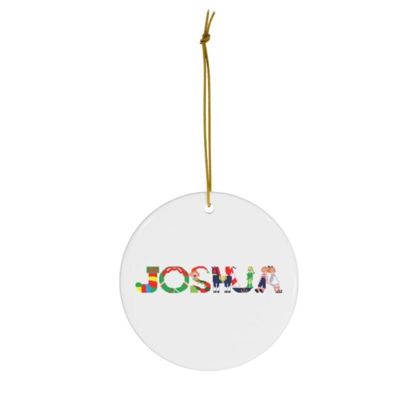 White ceramic ornament with text ‘Joshua’ in colourful Christmas themed lettering, with gold hanging loop