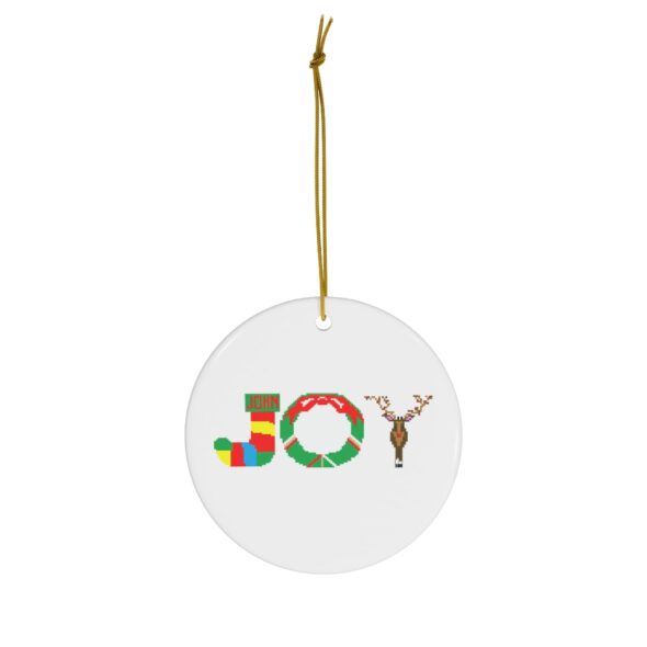 White ceramic ornament with text ‘Joy’ in colourful Christmas themed lettering, with gold hanging loop