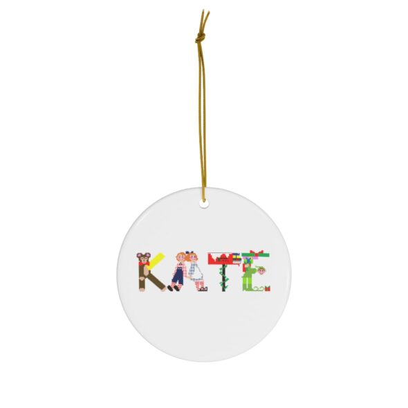 White ceramic ornament with text ‘Kate’ in colourful Christmas themed lettering, with gold hanging loop