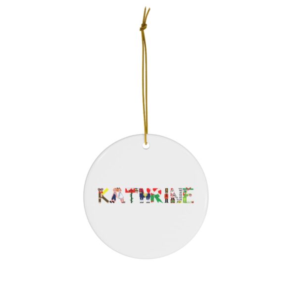White ceramic ornament with text ‘Kathrine’ in colourful Christmas themed lettering, with gold hanging loop