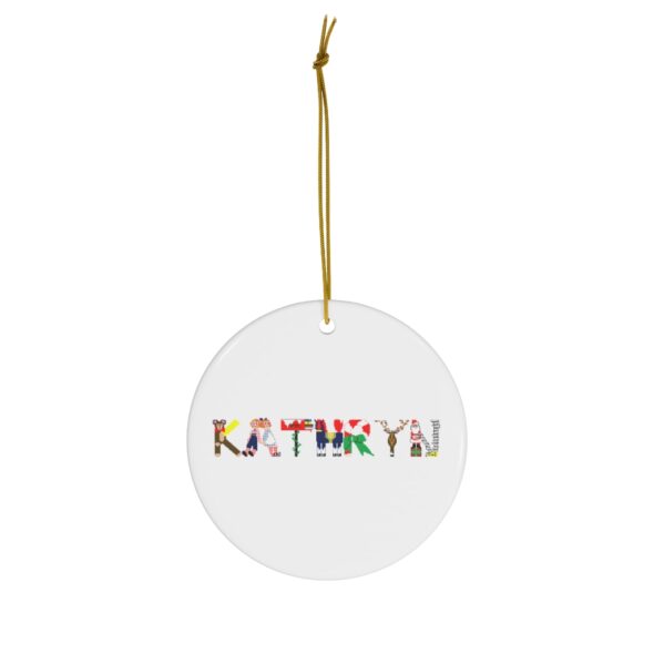 White ceramic ornament with text ‘Kathryn’ in colourful Christmas themed lettering, with gold hanging loop