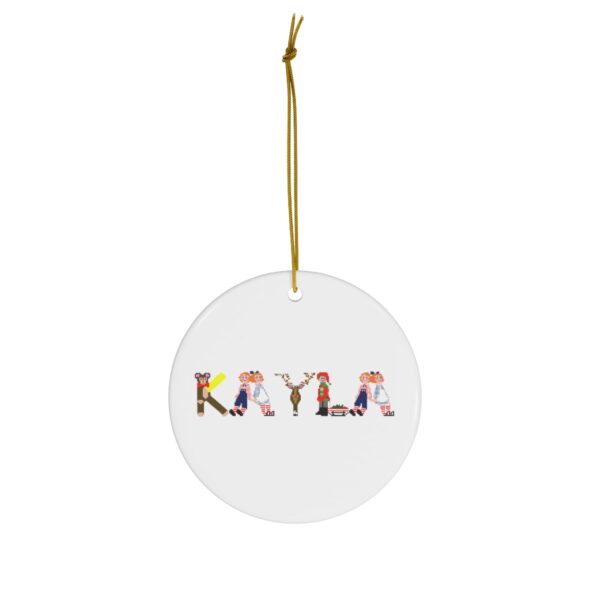 White ceramic ornament with text ‘Kayla’ in colourful Christmas themed lettering, with gold hanging loop