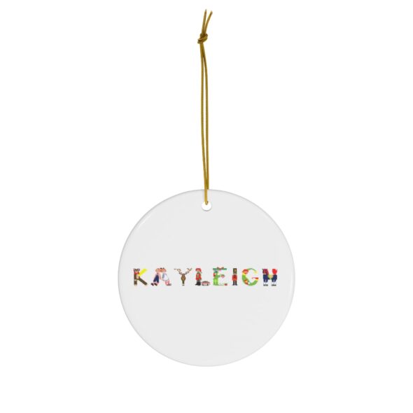 White ceramic ornament with text ‘Kayleigh’ in colourful Christmas themed lettering, with gold hanging loop