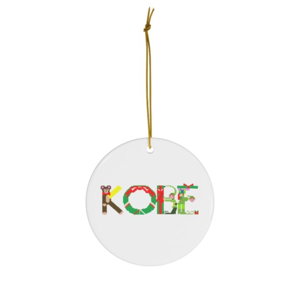 White ceramic ornament with text ‘Kobe’ in colourful Christmas themed lettering, with gold hanging loop