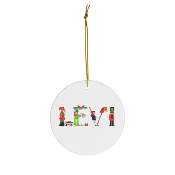White ceramic ornament with text ‘Levi’ in colourful Christmas themed lettering, with gold hanging loop