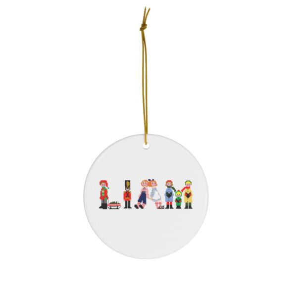White ceramic ornament with text ‘Liam’ in colourful Christmas themed lettering, with gold hanging loop