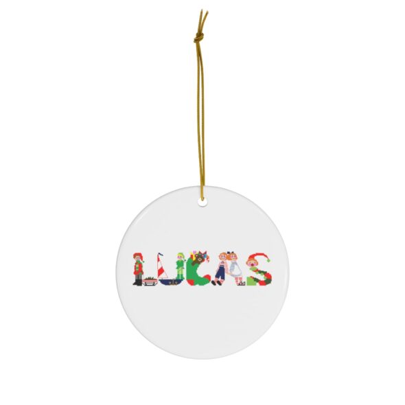 White ceramic ornament with text ‘Lucas’ in colourful Christmas themed lettering, with gold hanging loop