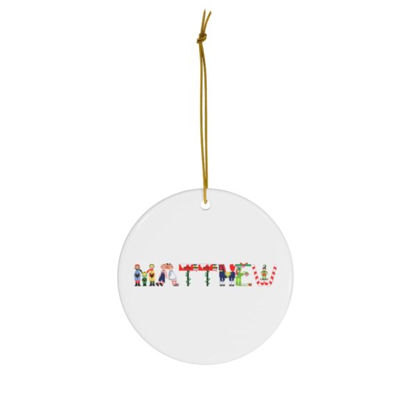 White ceramic ornament with text ‘Matthew’ in colourful Christmas themed lettering, with gold hanging loop