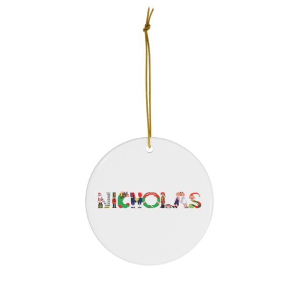 White ceramic ornament with text ‘Nicholas’ in colourful Christmas themed lettering, with gold hanging loop