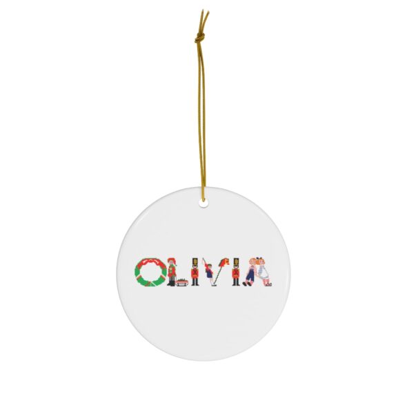 White ceramic ornament with text ‘Olivia’ in colourful Christmas themed lettering, with gold hanging loop