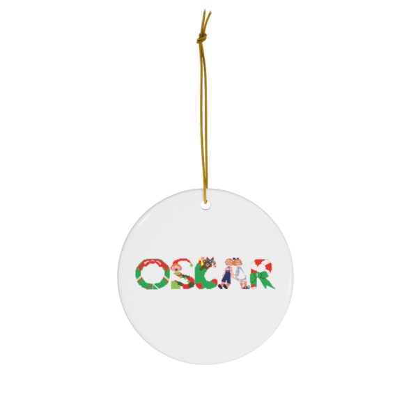 White ceramic ornament with text ‘Oscar’ in colourful Christmas themed lettering, with gold hanging loop