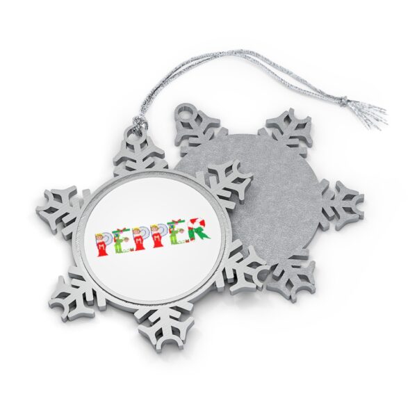 Silver-toned snowflake ornament with white insert with text ‘Pepper’ in colourful Christmas themed lettering, with silver hanging loop
