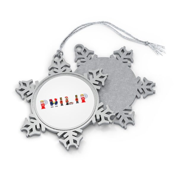 Silver-toned snowflake ornament with white insert with text ‘Philip’ in colourful Christmas themed lettering, with silver hanging loop