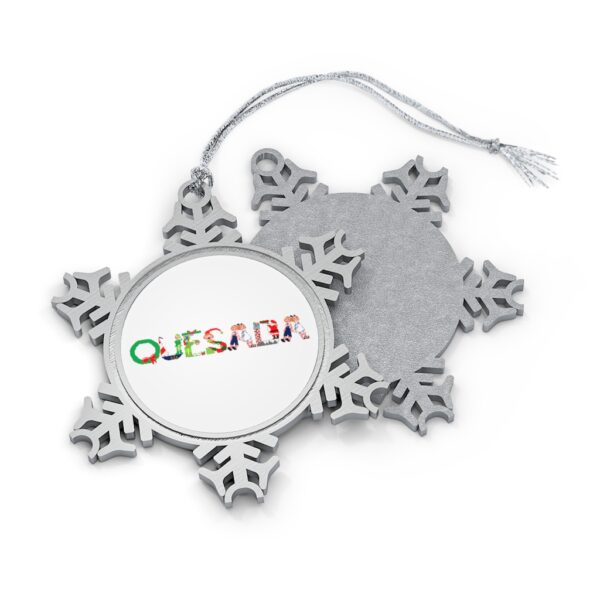 Silver-toned snowflake ornament with white insert with text ‘Quesada’ in colourful Christmas themed lettering, with silver hanging loop