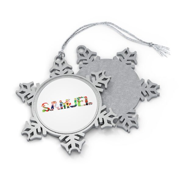Silver-toned snowflake ornament with white insert with text ‘Samuel’ in colourful Christmas themed lettering, with silver hanging loop