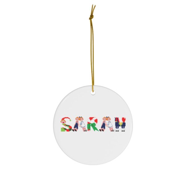 White ceramic ornament with text ‘Sarah’ in colourful Christmas themed lettering, with gold hanging loop