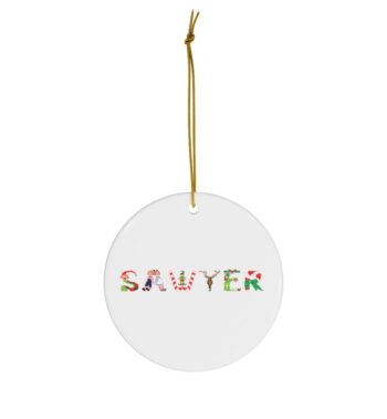 White ceramic ornament with text ‘Sawyer’ in colourful Christmas themed lettering, with gold hanging loop