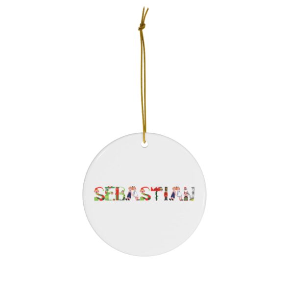 White ceramic ornament with text ‘Sebastian’ in colourful Christmas themed lettering, with gold hanging loop