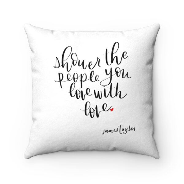 White faux suede cushion, featuring the lyric ‘Shower the people you love with love’ in the shape of a heart