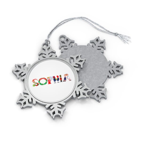 Silver-toned snowflake ornament with white insert with text ‘Sophia’ in colourful Christmas themed lettering, with silver hanging loop