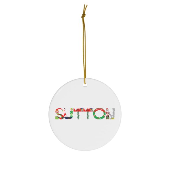 White ceramic ornament with text ‘Sutton’ in colourful Christmas themed lettering, with gold hanging loop