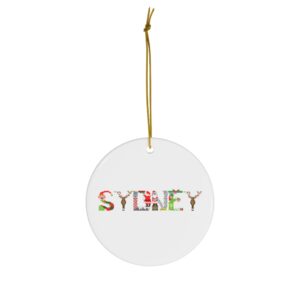 White ceramic ornament with text ‘Sydney’ in colourful Christmas themed lettering, with gold hanging loop